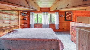 A wooden cabin bedroom with a bed, dresser, and bookshelves. - Near State Parks: Countryside Cottage in Wellsboro (Wellsboro)