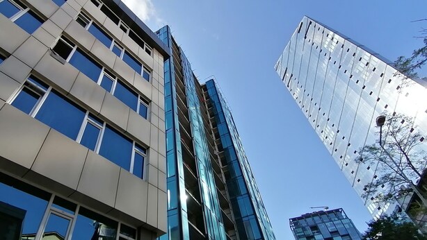 A modern building with multiple floors, large windows, and a reflective glass facade. - Non-Smoked Apartments at Levent (İstanbul)