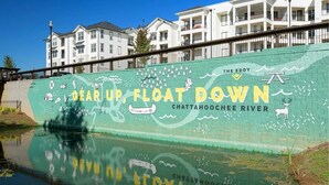 A mural on a building wall with the text "GEAR UP, FLOAT DOWN" and "THE EDDY CHATTATOCHOOE RIVER".