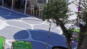 Ein Parkplatz mit gemustertem Belag, einem Baum und einem grünen Gegenstand.