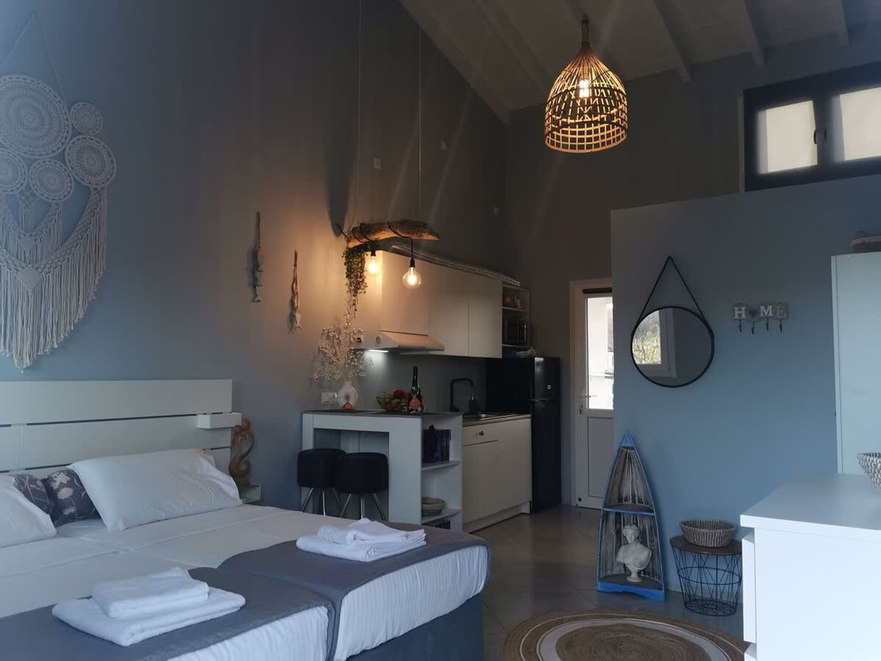 Un dormitorio moderno con una cama grande, una kitchenette y un comedor.