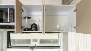 A kitchen with a built-in microwave, a blender, and a window with a view. - NOK Amazing Duplex in Parque 93 (Bogotá)
