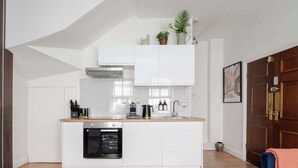 A modern kitchen with white cabinetry, a built-in oven, and a coffee station. - Stunning Apartment in the ❤️ of Mayfair ❄️ Air Conditioning | Sleeps 5 (Greater London)