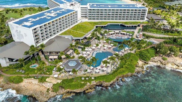 Et resort med flere bygninger, et poolområde og en strand.