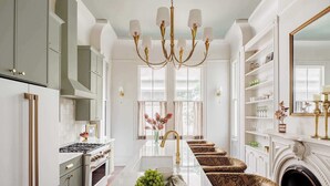 A kitchen with a central island, a chandelier, and a fireplace. - The Estella | 12-bedroom Suite, Shared Pool (New Orleans)
