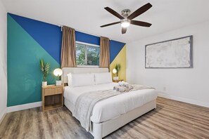 Relax in this serene bedroom with a large bed, two nightstands, and a ceiling fan.