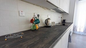 A modern kitchen with a dark wooden countertop, a kettle, and a coffee maker. - Valletta Penthouse Cathedral view Terrace (Valletta)