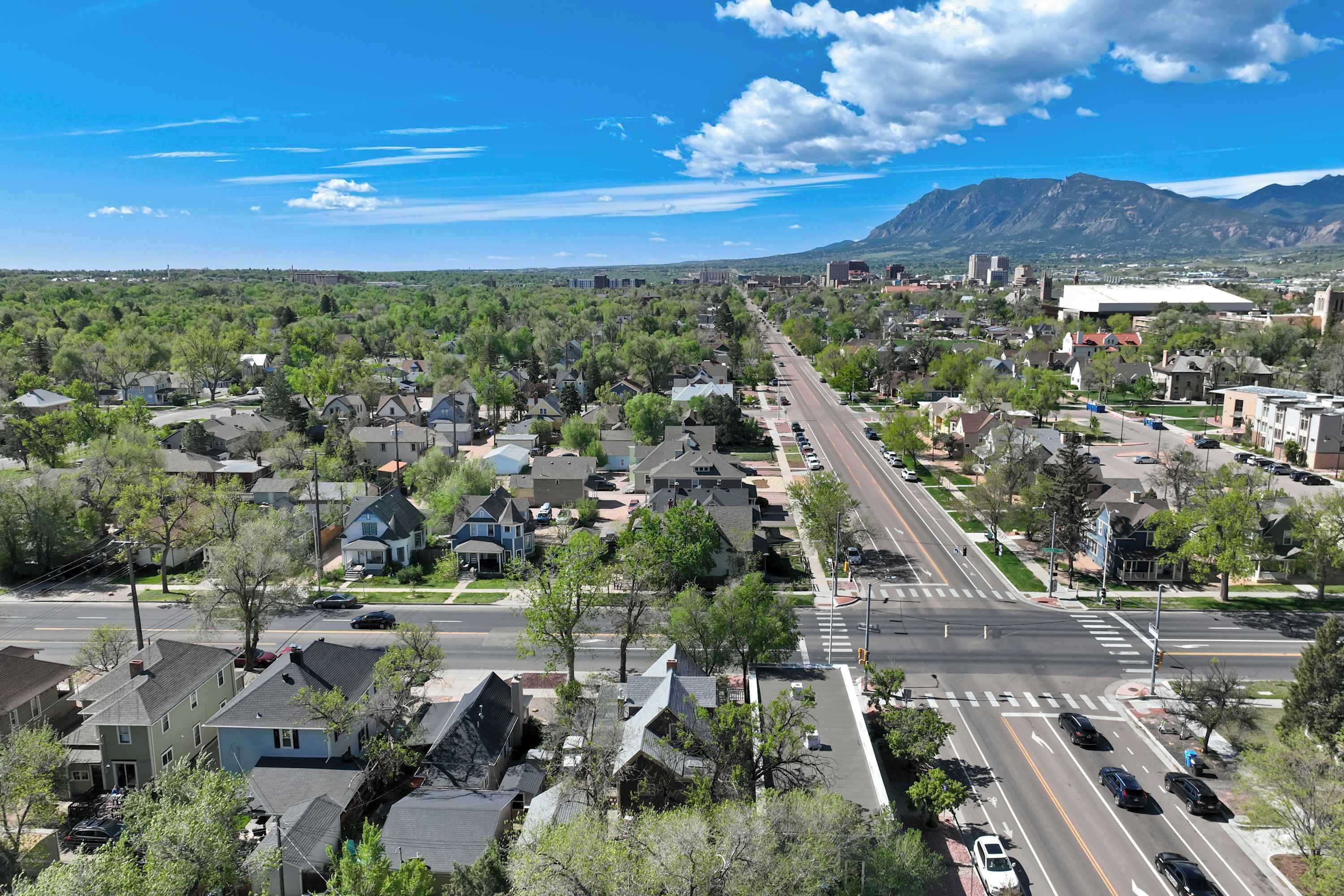 Un quartier résidentiel avec des maisons, des rues et, au loin, une chaîne de montagnes.