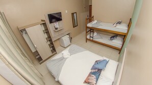 A hotel room with a bunk bed, a desk with a chair, a TV, and a wardrobe. - Pousada 4 Estações (Penha)