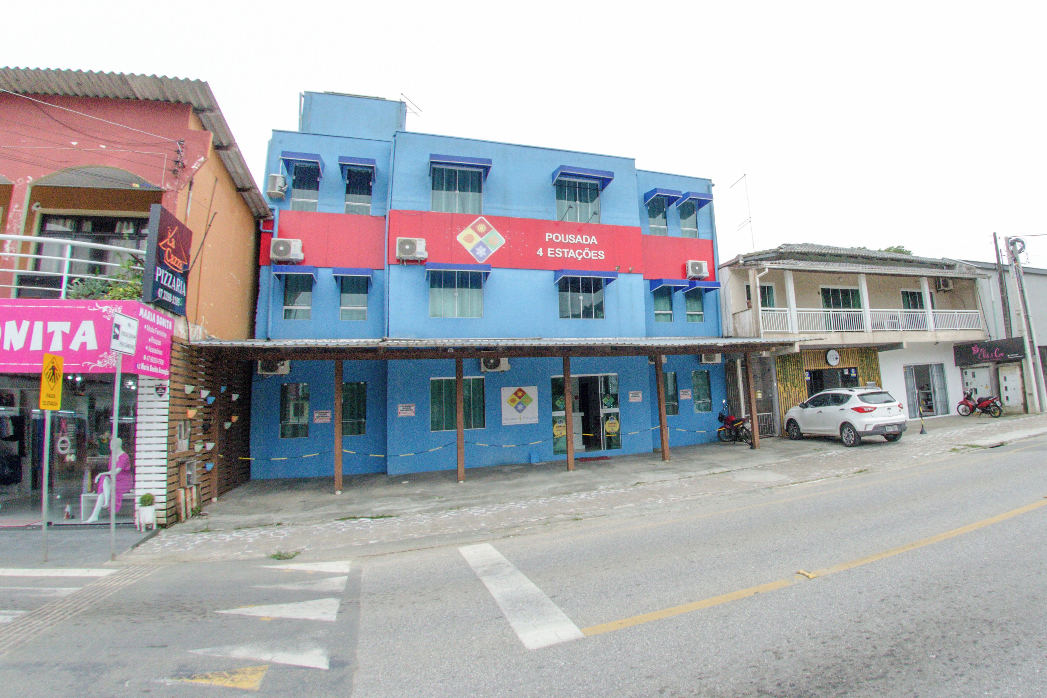 Un edificio con fachada azul y un letrero rojo que indica 'POUSADA 4 ESTAÇÕES'.