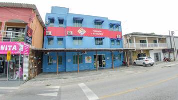 Un edificio con fachada azul y un letrero rojo que indica 'POUSADA 4 ESTAÇÕES'.