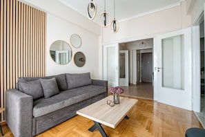 Relax in this stylish living room with a comfortable sofa, coffee table, and beautiful mirrors.