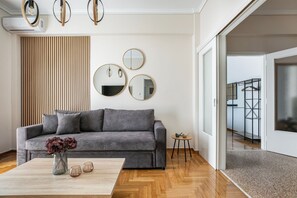 Appartamento Deluxe, balcone, vista città | Area soggiorno | Smart TV 50 pollici con canali digitali, Netflix, servizi in streaming