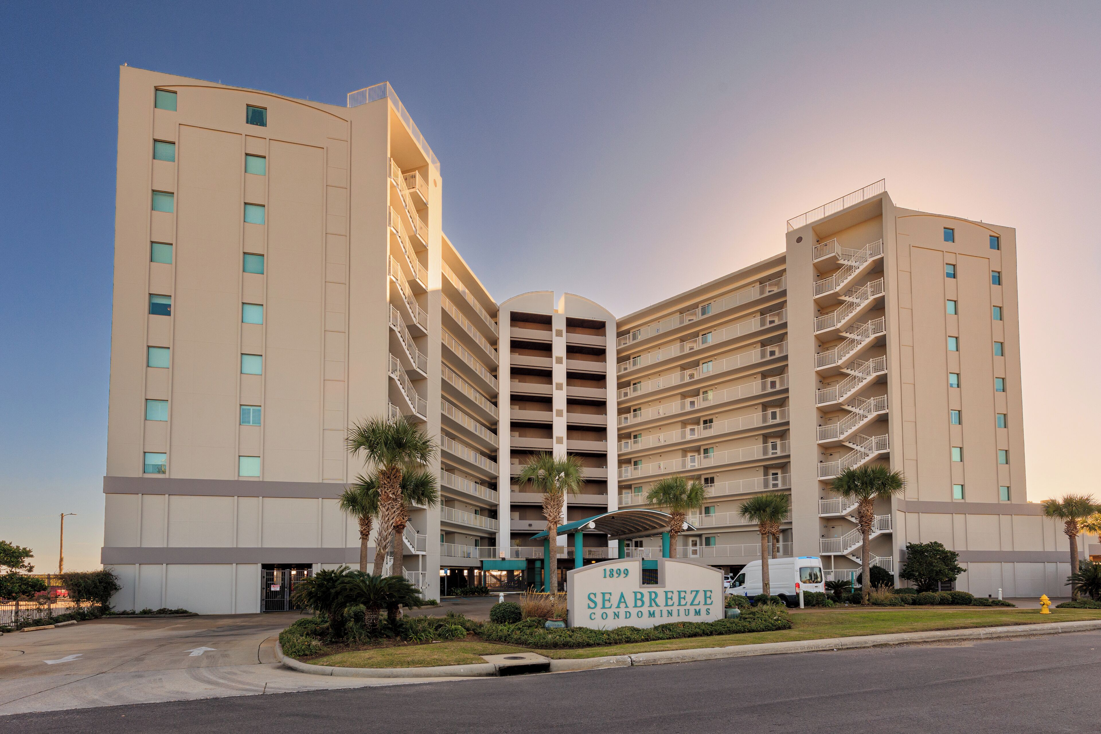 A multi-story hotel with a central entrance, balconies on each floor, and a sign indicating the name and year of establishment.