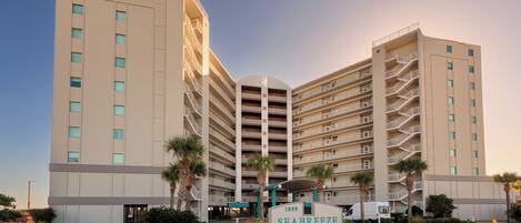 A multi-story hotel with a central entrance, balconies on each floor, and a sign indicating the name and year of establishment.