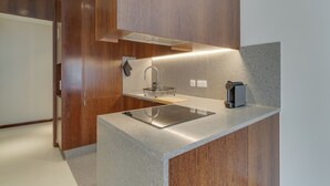 A modern kitchen with a built-in stove, a sink, and a coffee maker. - Urso Tigre Apartment (Funchal)