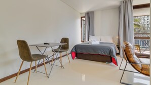 A bedroom with a bed, a desk, two chairs, and a balcony view. - Urso Tigre Apartment (Funchal)