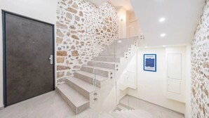 A staircase with a stone wall, a door, and a poster on the wall. - Luxury 115-square-meter apartment in a 1679 palace, 2 minutes from the beach and Antibes' Old Town, sleeps 6 adults (Antibes)