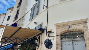 A building with a cafe bar sign, a number 8 sign, and a door with a keypad lock. - Very large, refined apartment in the heart of old Antibes (Antibes)