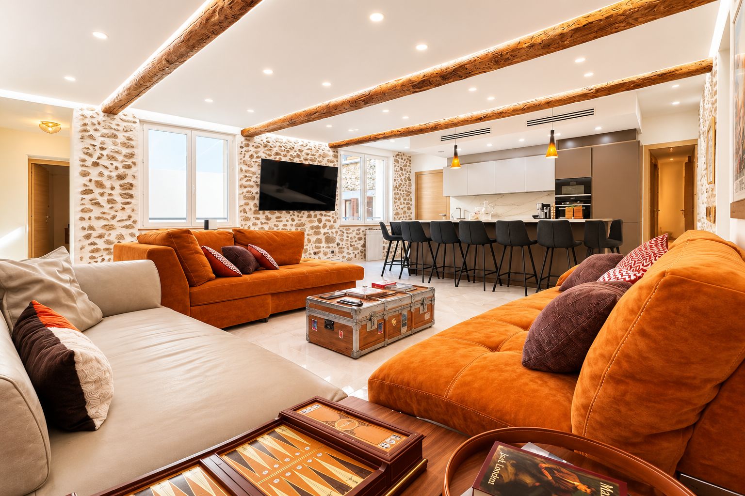 A modern living room with a sofa, ottoman, and a coffee table with a vintage suitcase.