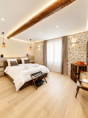 Een moderne slaapkamer met een groot bed, een houten plafond en een stenen muur.