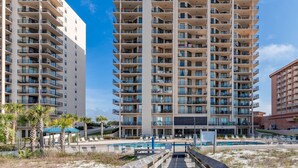 A multi-story hotel with balconies, a pool area, and a beach view. - Phoenix East 2 2074 2 Bedroom Condo (Orange Beach)