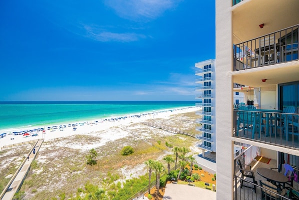 A beachfront hotel with balconies, a beach view, and a pier.