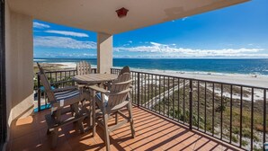 Uma varanda com vista para a praia e o oceano.