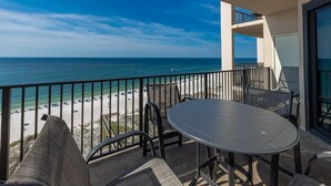 Ein Balkon mit Blick auf Strand und Meer.