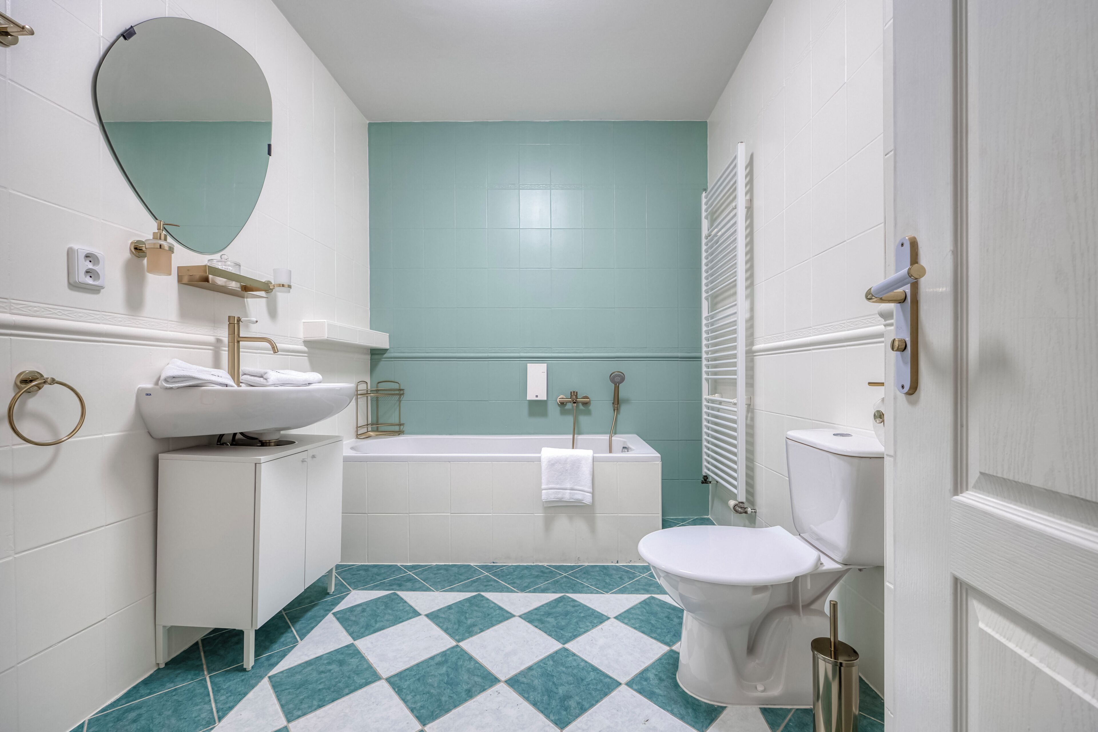A bathroom with a white sink, a toilet, a bathtub, and a mirror.
