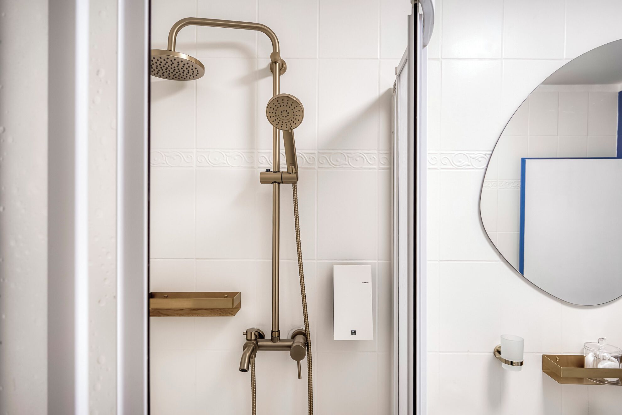 Une salle de bain avec une douche à parois de verre, un miroir fixé au mur et un porte-serviettes.