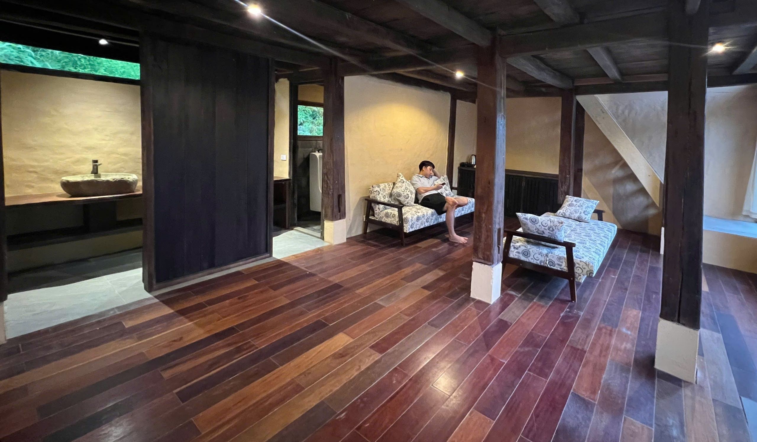 Une pièce spacieuse avec un plancher en bois, un canapé, un lit et une petite table.
