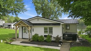Une maison de plain-pied avec un porche à l’avant, un garage et une petite terrasse.