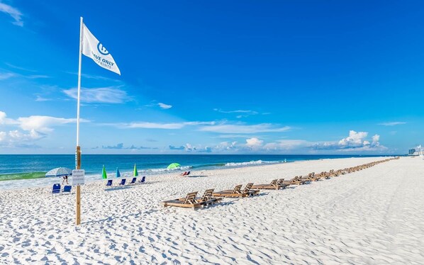 Relax on the beach with lounge chairs and umbrellas for shade.