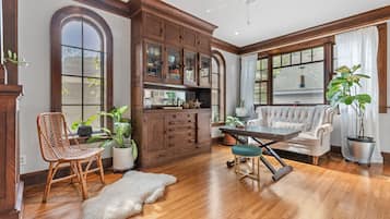 Relax in this stylish living room with a sofa, dining table, and potted plants.