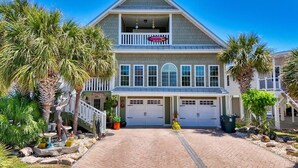 A two-story house with a balcony, a garage, and a driveway. - A Lady's Place (North Myrtle Beach)