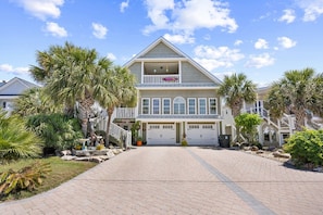 A two-story house with a front porch, garage, and a landscaped driveway.