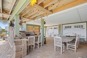 Un patio al aire libre con asientos de piedra, una mesa de madera y una parrilla.