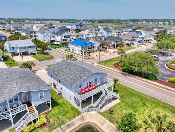 Un quartier résidentiel avec des maisons, un bâtiment doté d’un toit bleu et une route.