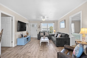A living room with a television, two sofas, a coffee table, and a lamp. - Waterfront Retreat 1 Block from the Beach Sleeps 8 (North Myrtle Beach)