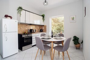 Apartamento, 2 quartos, vista para o jardim | Cozinha privada | Cadeirão de bebê, talheres/pratos/utensílios de cozinha