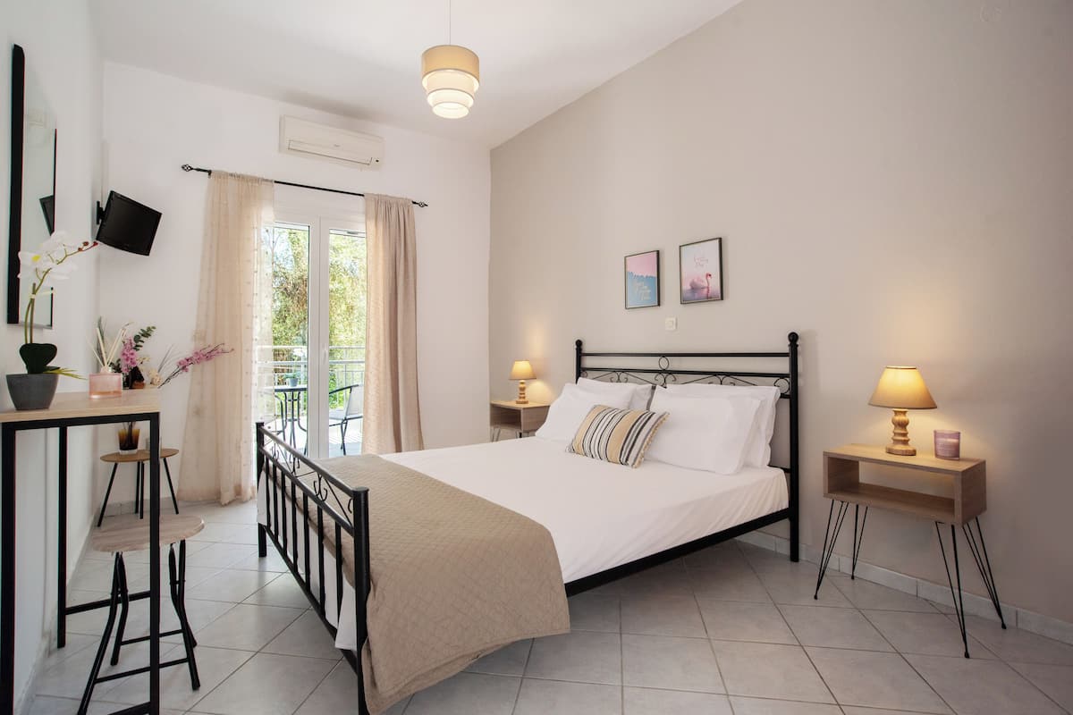 A bedroom with a bed, bedside tables, a desk, and a chair.