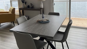 En matplats med ett stort bord, stolar och utsikt över en sjö.