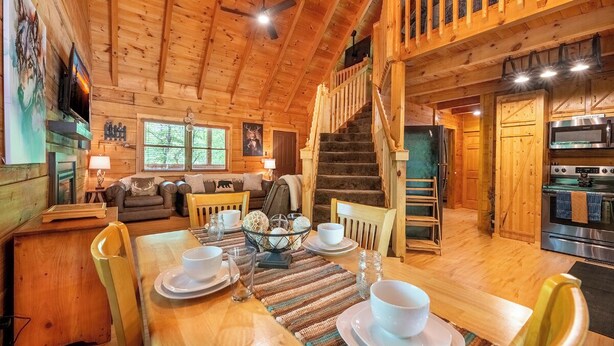 Ein Holzblockbau-Innenraum mit Essbereich, Treppe, Wohnzimmer und Küche.