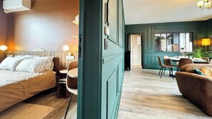 Una habitación de hotel con una cama, un escritorio y una zona de comedor.