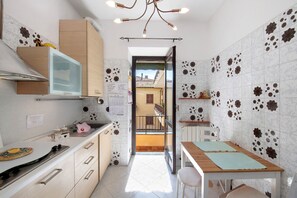 A kitchen with a countertop, cabinets, a window, and a door leading to a balcony. - Apartment 'La Terrazza Di Basilio' with Lake View, Balcony and Wi-Fi (Olginate)
