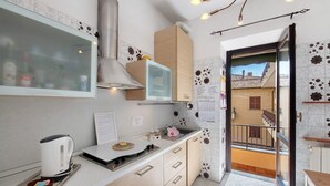 A kitchen with a microwave, kettle, and a small table with a plate. - Apartment 'La Terrazza Di Basilio' with Lake View, Balcony and Wi-Fi (Olginate)
