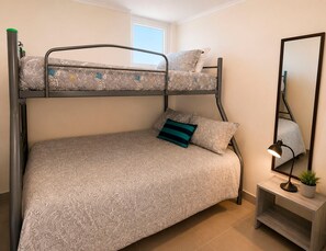 A bunk bed with patterned bedding, a bedside lamp, and a small plant on a nightstand. - Smart Host Rentals - A paradise for your family! (La Serena)