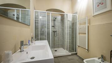 Ein Badezimmer mit zwei Waschbecken, einer Duschkabine und einem Bidet.