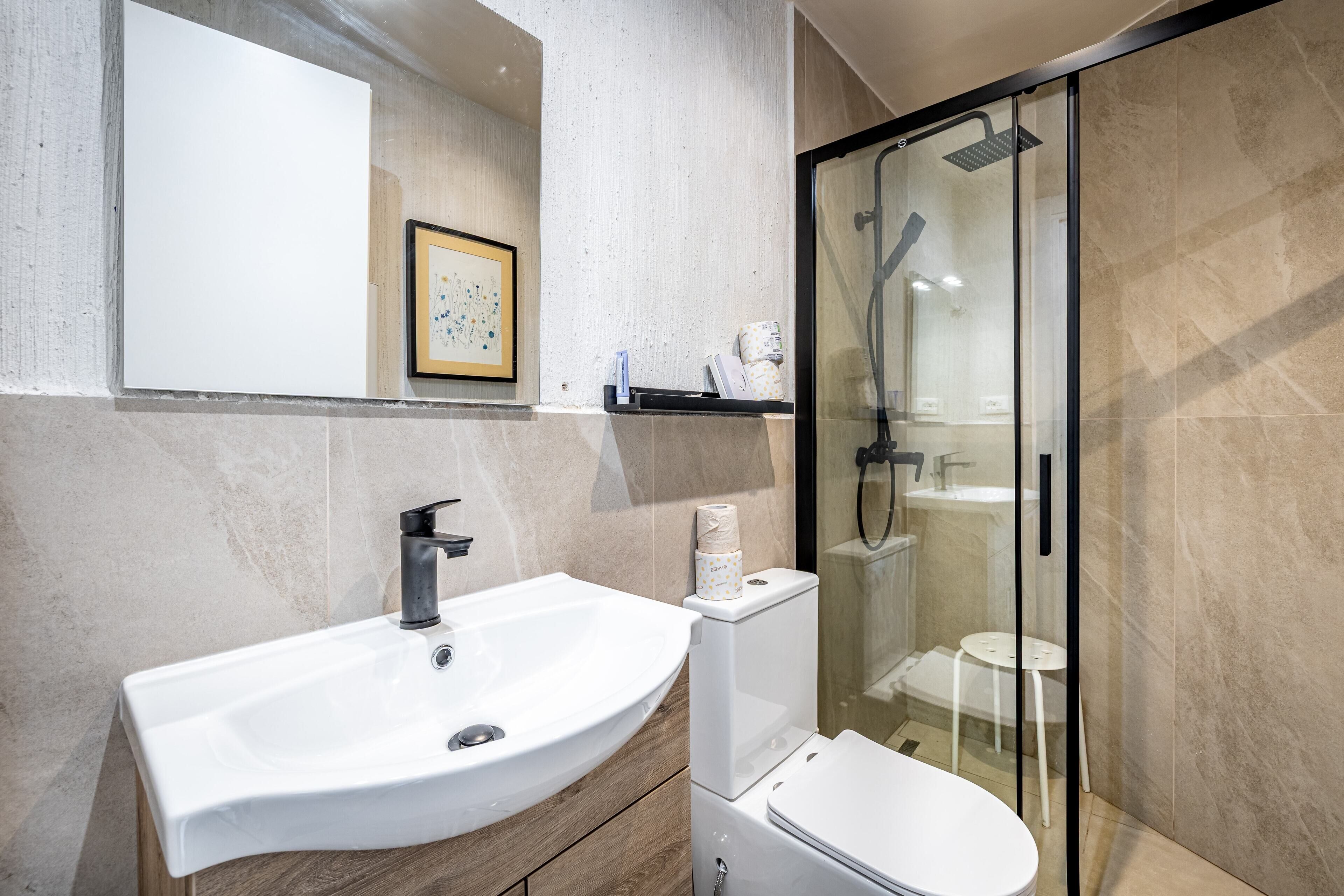 Ein modernes Badezimmer mit Waschbecken, Toilette und einer Duschkabine.
